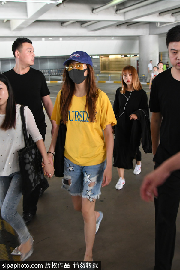 關曉彤黃T短褲踩拖鞋現身上海機場 獲眾人護駕見鏡頭比V賣萌